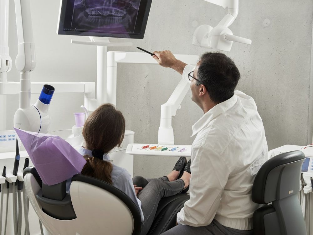 Dentist showing a patient her X-ray in a bright, modern dental office